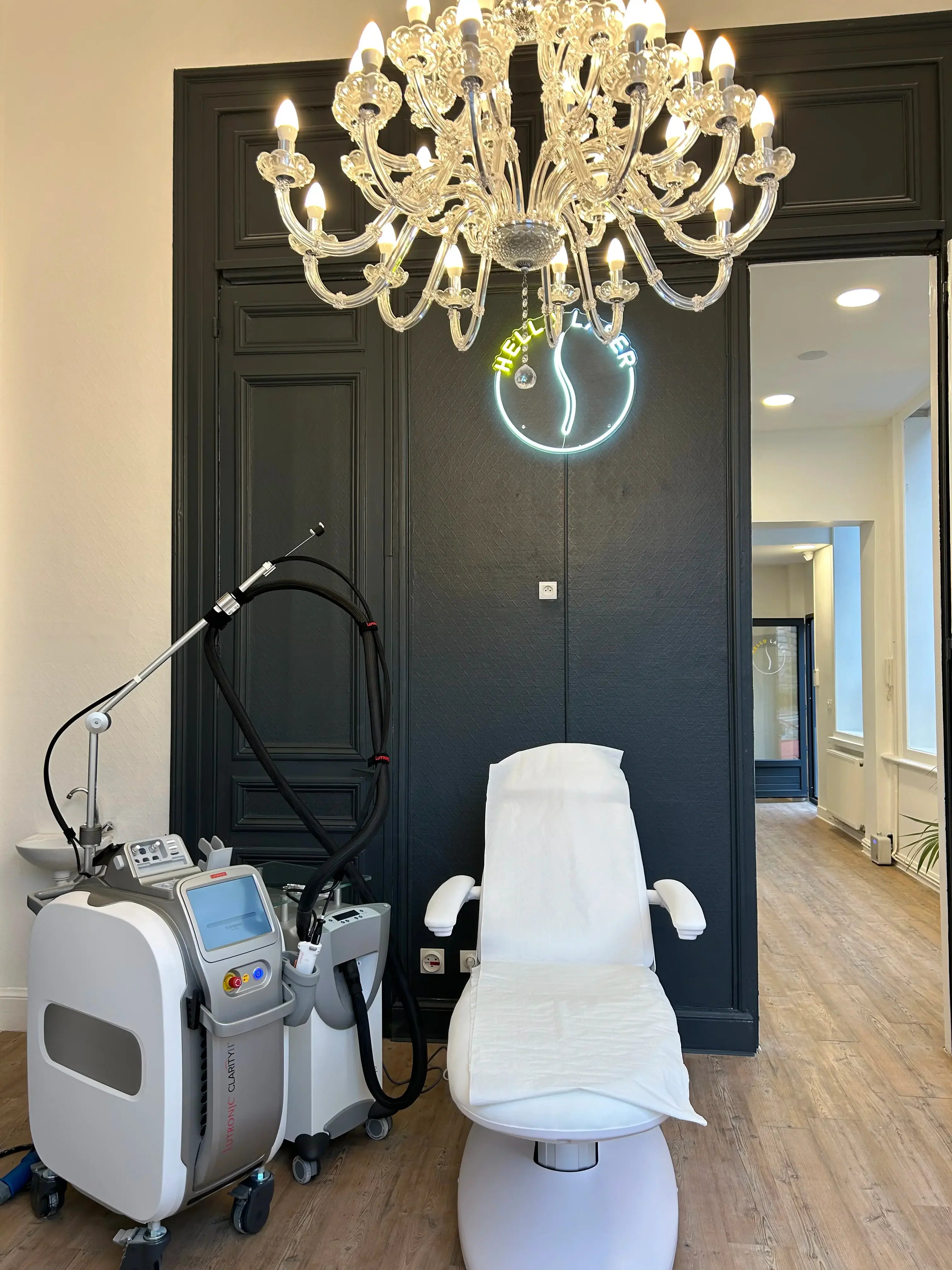 Modern laser hair removal clinic room with treatment chair and laser machine, HELLO LASER neon sign